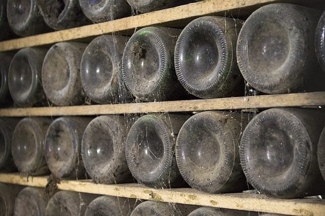 Archivní láhve s vínem, uložené ve sklepě